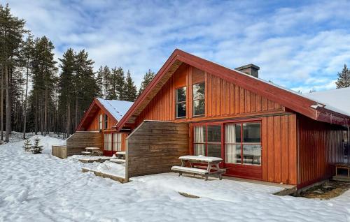 a log cabin in the snow with a picnic table at Stunning Apartment In Ljørdalen in Ljørdalen