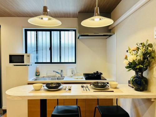 a kitchen with a counter with a sink and a table at ASOBO OSAKA Kuromon 2nd in Osaka