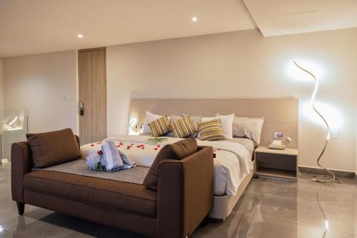 a bedroom with a large bed and a couch at Solmare Apartments & Suites in Akumal
