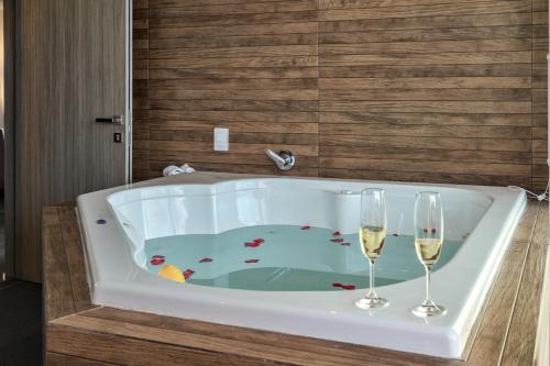 a bath tub with two glasses of wine at Solmare Apartments & Suites in Akumal