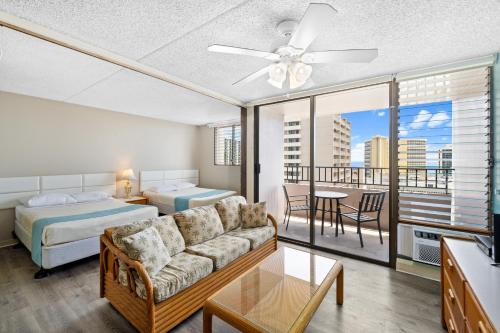 a living room with a couch and a bed at Royal Kuhio 1710 - Spacious Studio with Stunning Ocean City Views in the Heart of Waikiki! in Honolulu