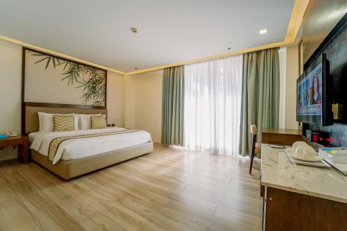 a hotel room with a bed and a large window at Boracay Haven Suites in Boracay