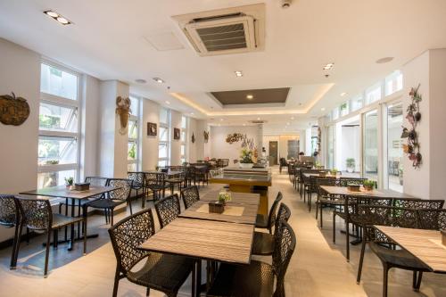 a restaurant with tables and chairs and windows at Boracay Haven Suites in Boracay