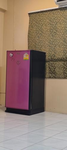 a purple refrigerator sitting next to a wall at Leisure Residence in Pattaya