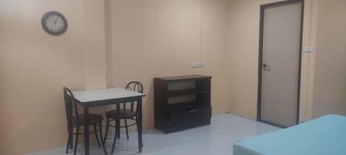 a room with a table and two chairs and a clock at Leisure Residence in Pattaya