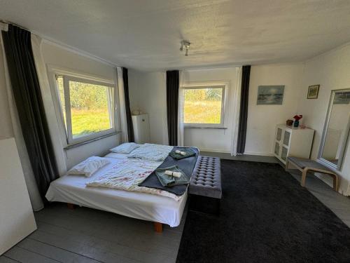 a bedroom with a large bed and two windows at House with playground visit Isaberg and High Chaparral in Dannäs