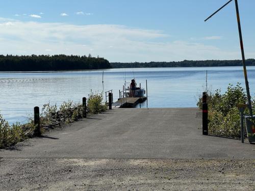 a person sitting on a dock on a lake at House with playground visit Isaberg and High Chaparral in Dannäs