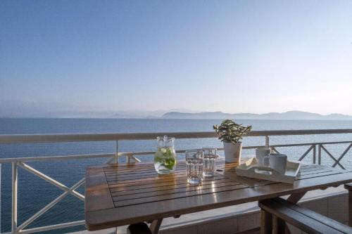 a wooden table on a balcony with a view of the ocean at Ferienwohnung Zesa Mit Balkon Und Meerblick in Kivérion
