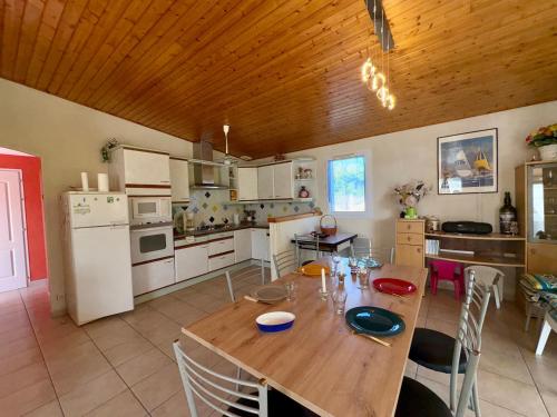 une cuisine avec une table en bois et des appareils électroménagers blancs dans l'établissement Charmante maison 2 chambres, proche plage, commerces, avec terrasse et WiFi à Saint-Jean-de-Monts - FR-1-323-284, à Saint-Jean-de-Monts