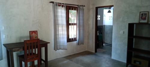 a room with a table and a window and a door at East Surf Cabana in Arugam Bay