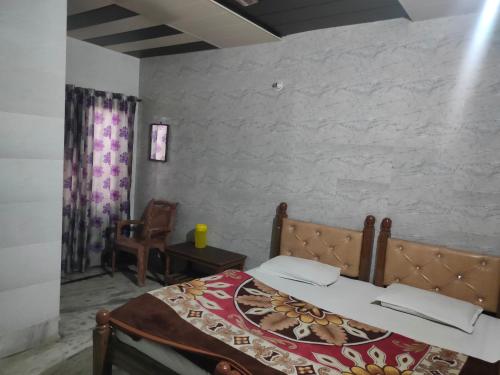 una camera da letto con un letto e una sedia di Hotel Subhadra Guest House a Mathura