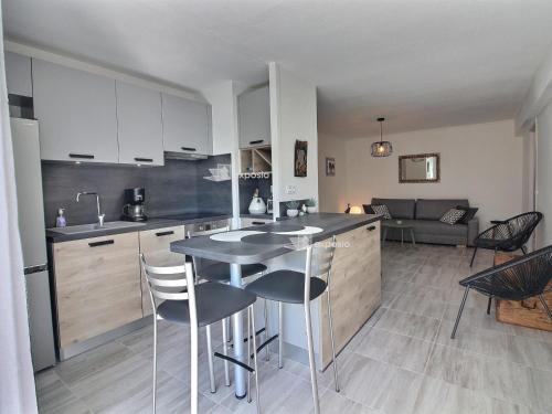 une cuisine avec une table et des chaises dans une pièce dans l'établissement Appartement moderne climatisé en bord de mer à Canet, animaux admis, parking inclus - FR-1-732-93, à Canet