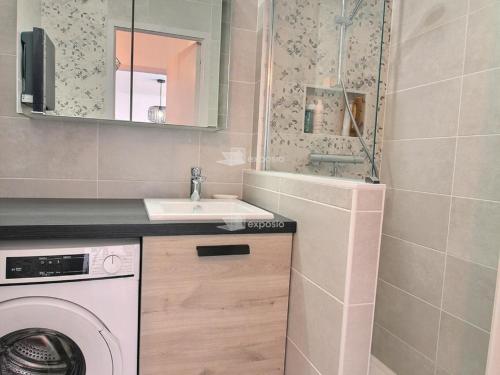 une salle de bain avec un lavabo et une machine à laver dans l'établissement Appartement moderne climatisé en bord de mer à Canet, animaux admis, parking inclus - FR-1-732-93, à Canet