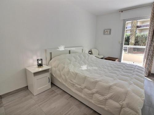 une chambre avec un grand lit et une fenêtre dans l'établissement Appartement moderne climatisé en bord de mer à Canet, animaux admis, parking inclus - FR-1-732-93, à Canet