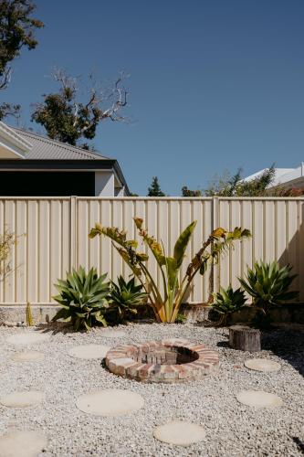 a garden with a fire pit in front of a fence at Papillon Dunsborough Family & Pet Friendly Holiday Home in Dunsborough