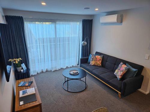 a living room with a couch and a table at Apartment in the Heart of Queenstown in Queenstown
