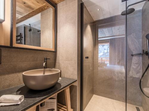 La salle de bains est pourvue d'un lavabo et d'une douche. dans l'établissement Appartement Luxueux avec Spa, Parking & Wi-Fi à Méribel - FR-1-613-60, à Les Allues