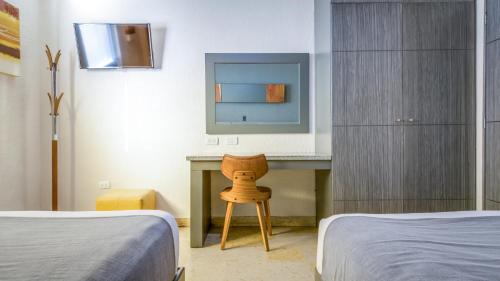a bedroom with two beds and a desk with a chair at Homesuites Rotarismo in Culiacán