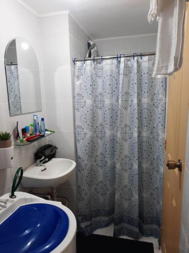 a bathroom with a blue shower curtain and a sink at Wave Crest Retreat at Marina Spatial Dumaguete in Dumaguete