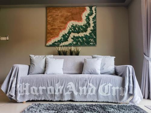 a couch in a living room with a painting on the wall at SUPERB Klean & Cozy Midhill in Genting Highlands