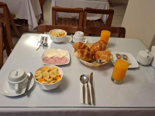 a table with a breakfast of croissants and other foods at Kuntur House Machupicchu in Machu Picchu