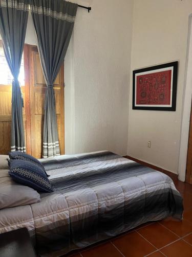 a bedroom with a large bed with a window at Departamento Yotao in Oaxaca City