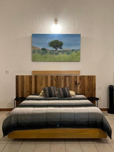 a bedroom with a bed with a tree in the background at Departamento Yotao in Oaxaca City