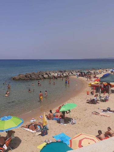 a crowd of people on a beach with umbrellas at Sunshine Apartments in Trappeto