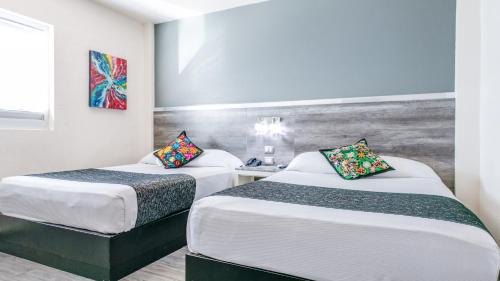 a hotel room with two beds and a window at Homesuites Rotarismo in Culiacán