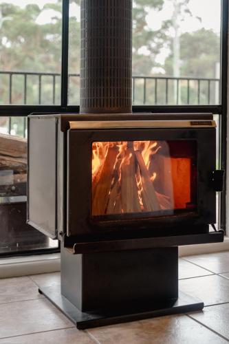 estufa con chimenea en la habitación en Acacia at Boardwalk Villas, en Metung