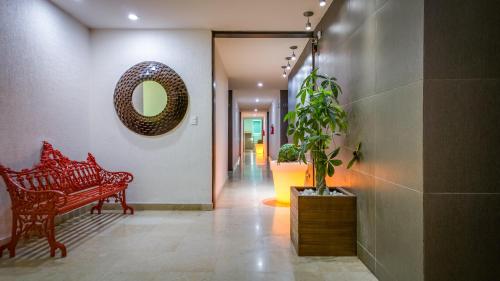 a hallway with a red bench and a mirror at Homesuites Rotarismo in Culiacán
