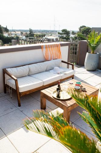 d'un canapé installé sur un balcon avec une table. dans l'établissement Le rooftop - jacuzzi et climatisation, à Montpellier