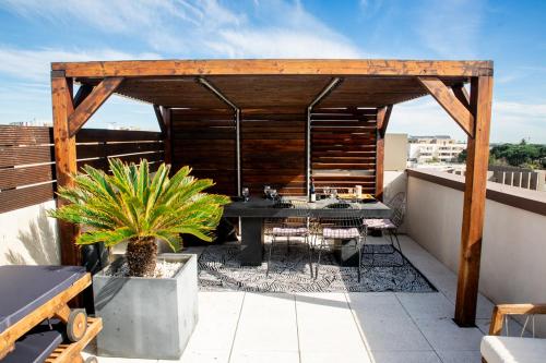 un patio avec une table et des chaises sur un toit dans l'établissement Le rooftop - jacuzzi et climatisation, à Montpellier