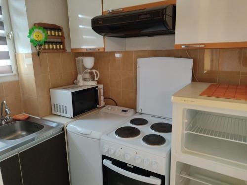 une petite cuisine avec une cuisinière et un micro-ondes dans l'établissement Studio à Gruissan pour 3 pers, vue port, parking privé - FR-1-796-89, à Gruissan