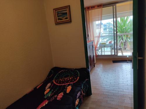 - une chambre avec un lit et une porte donnant sur un balcon dans l'établissement Studio à Gruissan pour 3 pers, vue port, parking privé - FR-1-796-89, à Gruissan