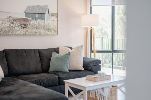 a living room with a couch and a table at Blackwood at Boardwalk Villas Metung in Metung