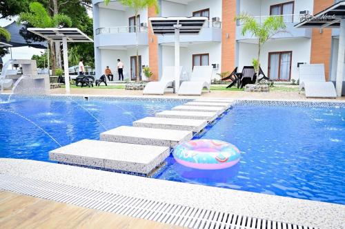 a swimming pool with chairs and a ball in the water at Crown of the Orient Beach Resort in Gloria
