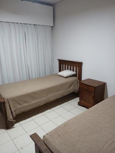 a bedroom with two beds and a dresser and a window at Departamento Martirena in Colón Buenos Aires Province