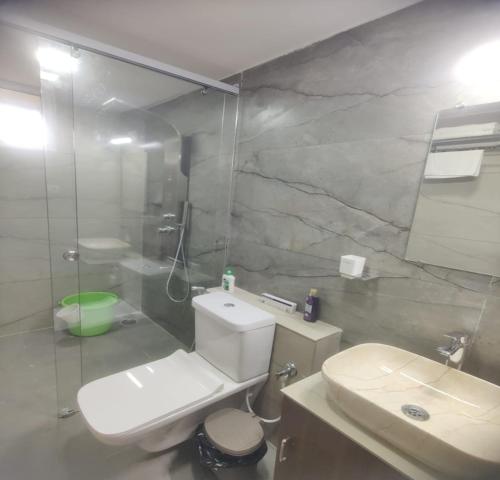 a bathroom with a white toilet and a sink at Cosmic Connect Trails Kabini in Antarasante