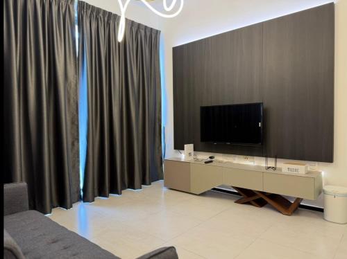 a living room with a flat screen tv and curtains at Urban Suites @ George Town Penang by BNB4U in George Town