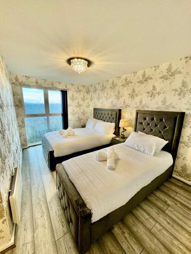 a bedroom with two beds and a chandelier at City View Apartments in Manchester