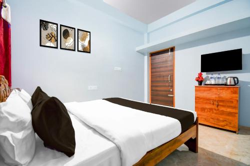 Un dormitorio con una cama y una cómoda con televisión. en Hotel O Spacious Villa, en Bhubaneshwar