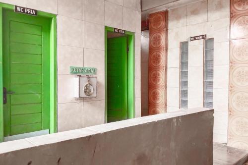 zwei grüne Türen an der Seite eines Gebäudes in der Unterkunft RedDoorz at DST RSU Banjar Guest House Syariah in Pataruman