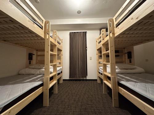 a room with three bunk beds with a window at Guesthouse Sign in Kyoto