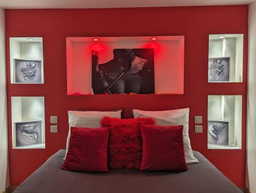 a bedroom with red walls and a bed with red pillows at Dark Room Perpignan aux 50 nuances Jacuzzi Privé in Villeneuve-de-la-Raho