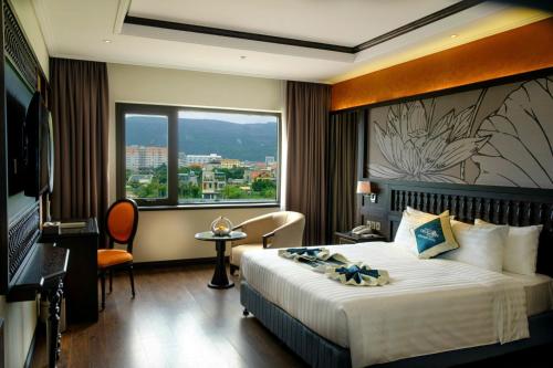 a hotel room with a bed and a large window at Green Dragon Boutique Hotel in Cẩm Phả
