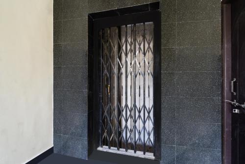 a door with a iron gate on a wall at Hotel O Shiridi serinity residency in Hyderabad