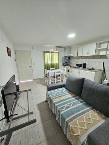 a living room with a couch and a kitchen at Departamentos Ríos del Neuquén in Neuquén