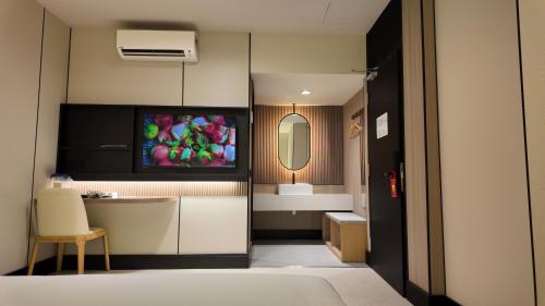 a hotel room with a bathroom with a television on the wall at Urban Inn Cyberjaya in Cyberjaya