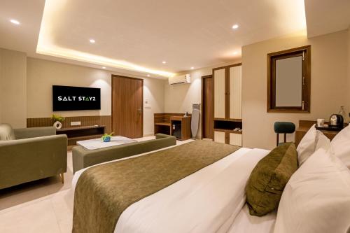 a hotel room with a large bed and a tv at Saltstayz Premier - Paschim Vihar in New Delhi